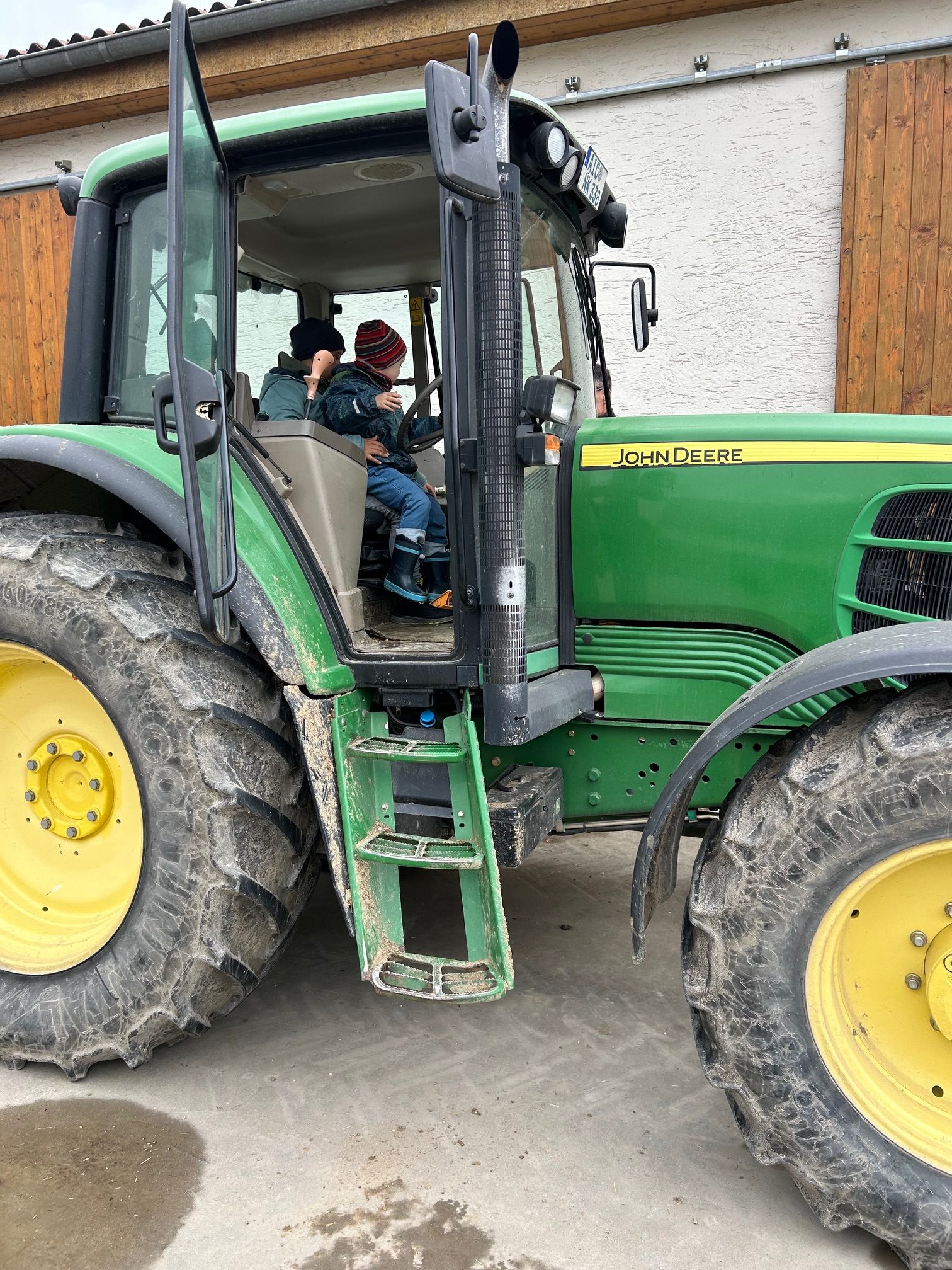 Eine Fahrt auf den kleinen Tret-Traktoren zum Kuhstall